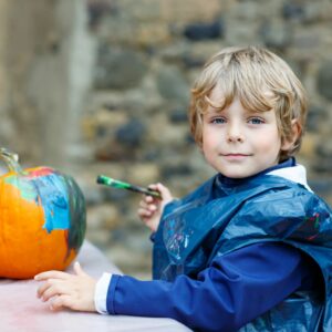 A child painting a pumpkin.